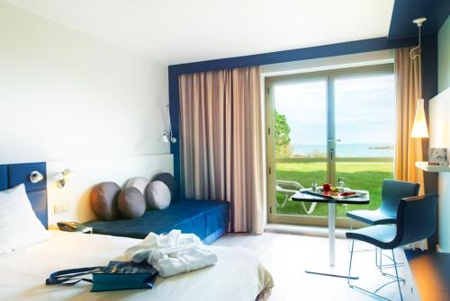Superior sea side room with one queen size and one single beds offering a direct access to the garden with private long chairs